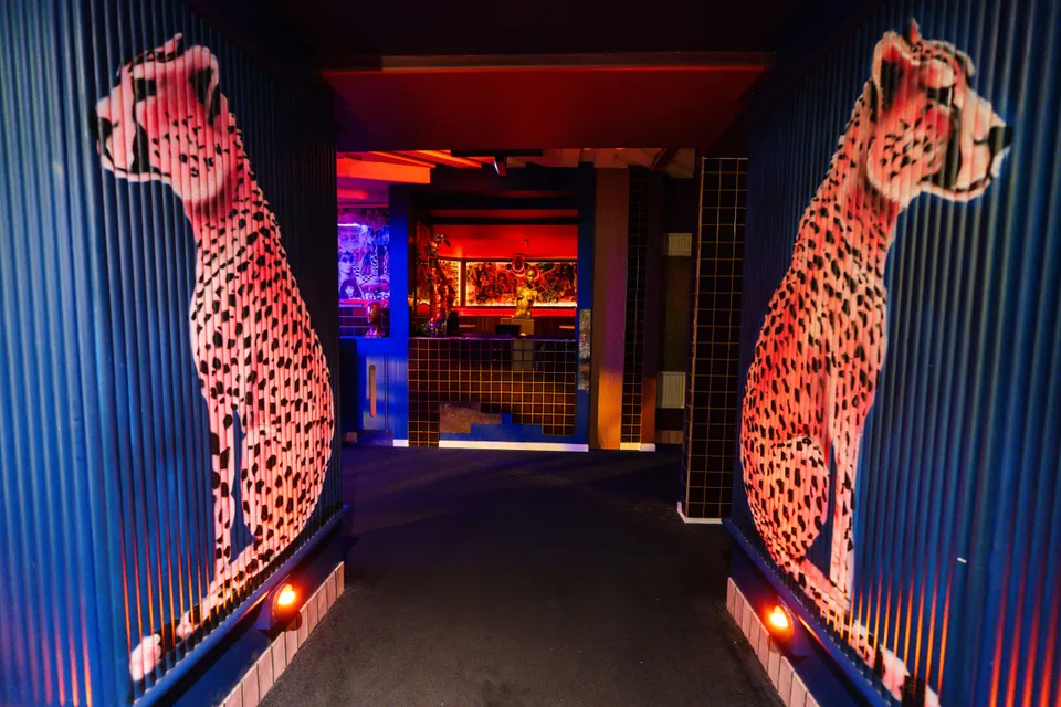 Two neon-pink cheetah murals flank the entrance to the Pelicano Disco Room